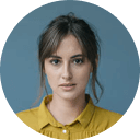 Foto de Jessica Robins, de pelo marrón oscuro amarrado, de tez clara y camisa amarilla.