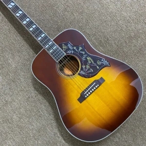 Guitarra acústica de madera con cuerdas de metal y un diseño de flores, mariposas y un colibrí en la caja.